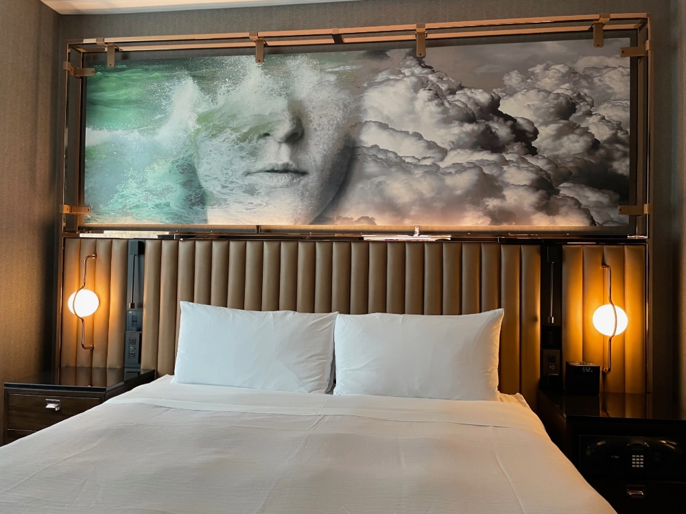 abstract artwork hanging over a king bed in a hotel room