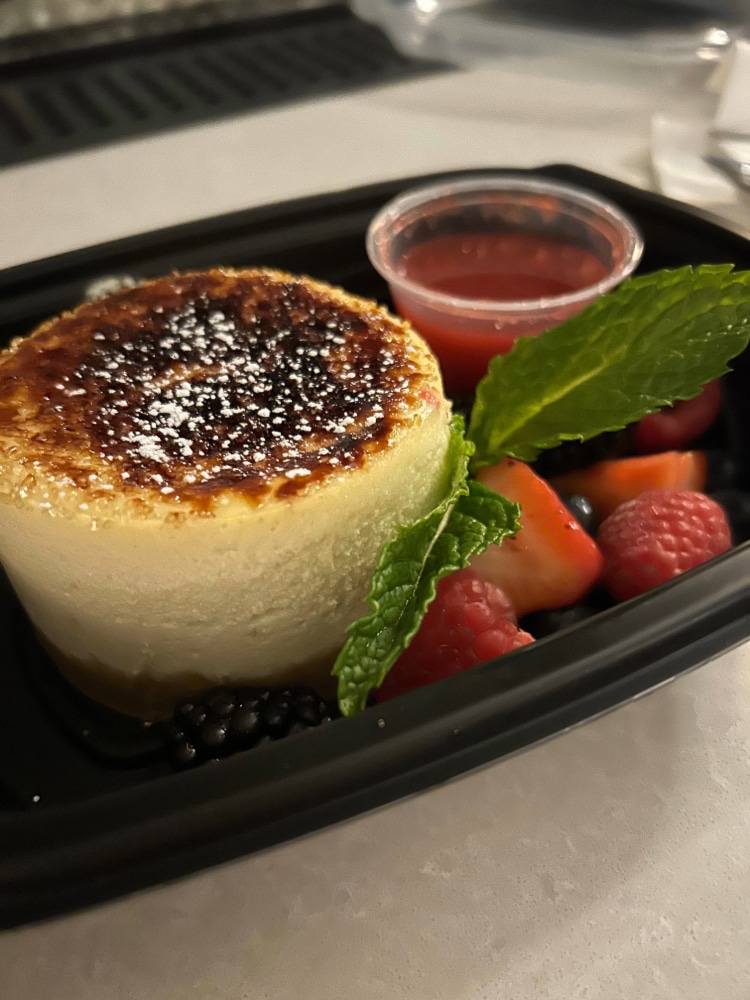 creme brûlée with berries and a sprig of mint
