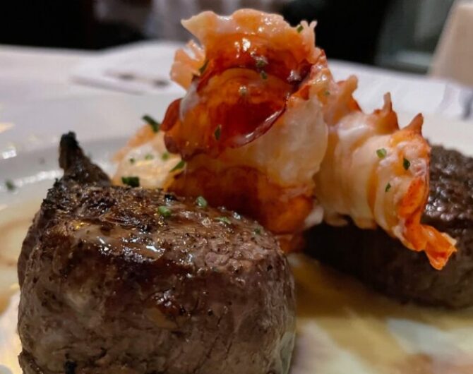close up view of tenderloin steak topped with poached lobster tail