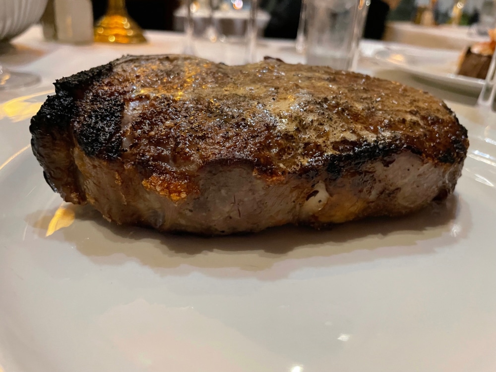 grilled rib eye steak on a white plate