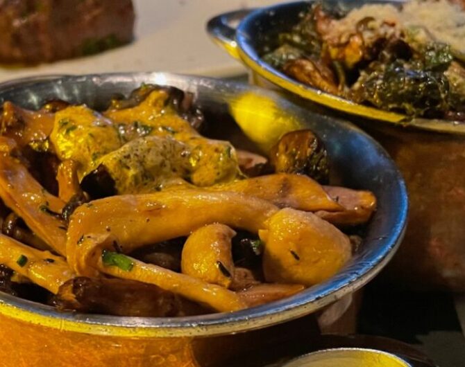 mushroom and brussel sprouts sidedishes in copper pots on a table