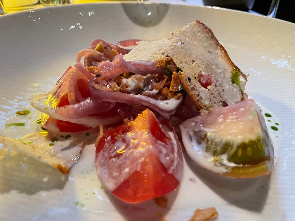 salad with heirloom tomatoes and onions with creamy dressing drizzle