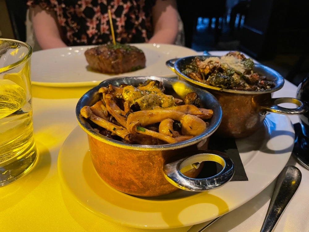 wild mushrooms and Brussels spouts side dishes on a small dining table