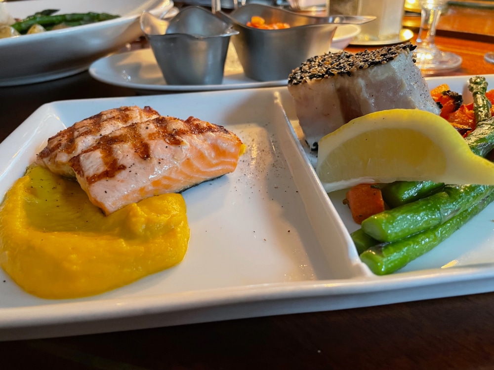 grilled salmon, albacore tuna, vegetables and a lemon wedge
