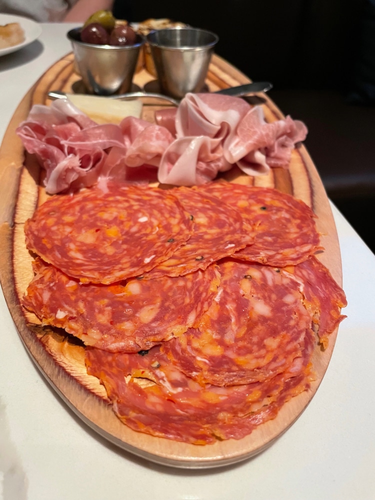 oval plate with charcurterie meats, cheese and olives