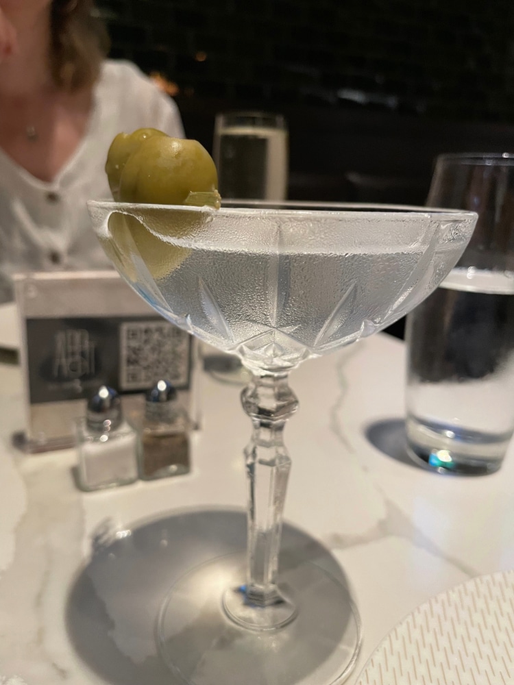 Martini with an olive on a restaurant table