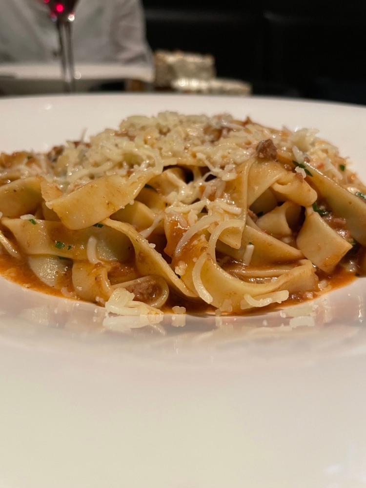plate of pasta topped with grated parmesan cheese