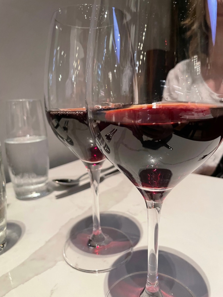 two glasses of red wine on a restaurant table