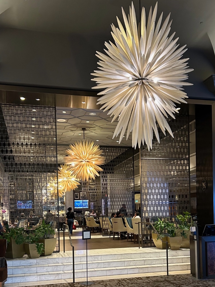 lobby of a hotel bar with large modern chandeliers