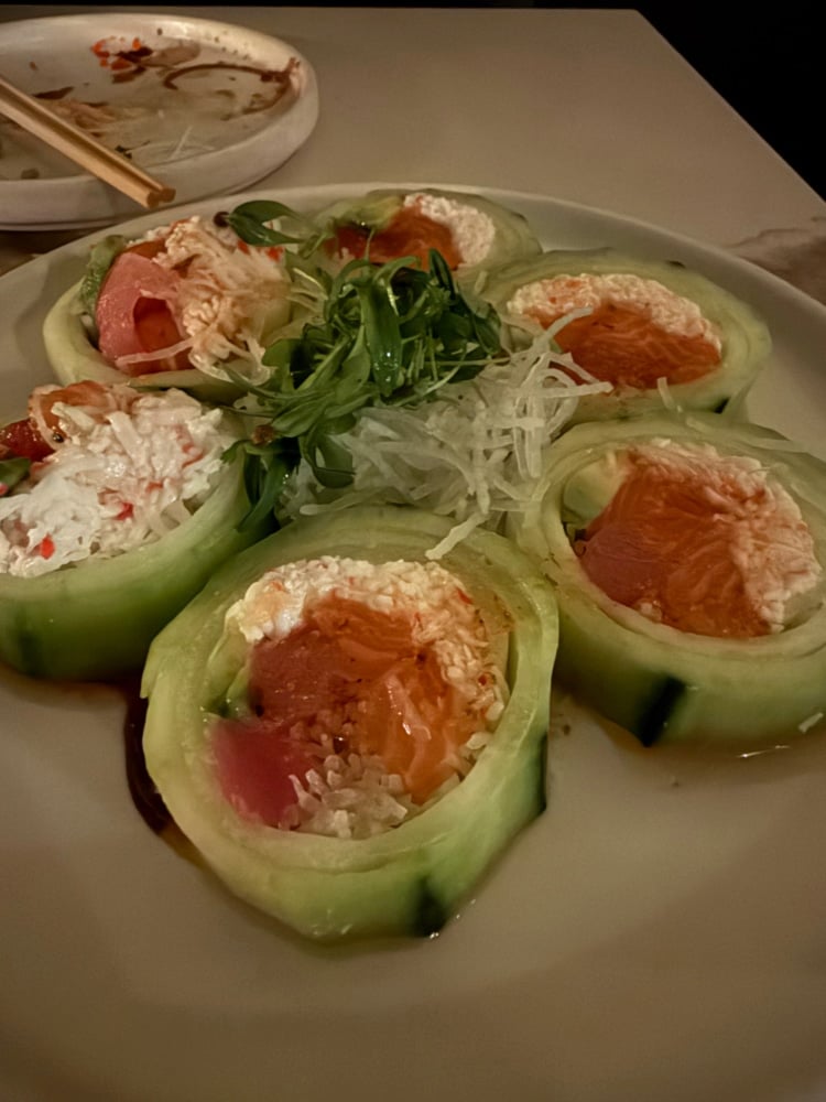 cucumber wrapped sushi rolls on a white plate