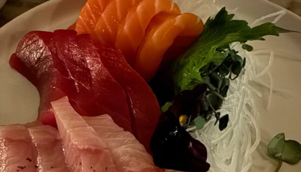 three kinds of sashimi with garnish on a white plate