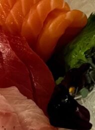 three kinds of sashimi with garnish on a white plate