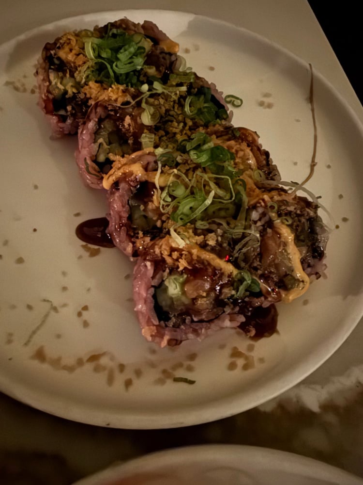 sushi roll with purple rice on a white plate