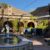 fountain with a stone statue in an outdoor courtyard flanked by several tables