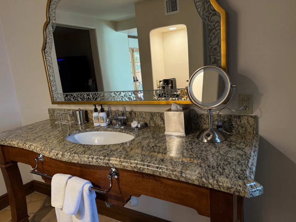 a granite vanity with a large mirror
