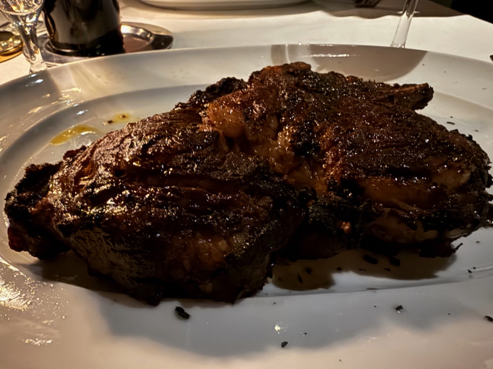 a large cut of steak served on a white plate