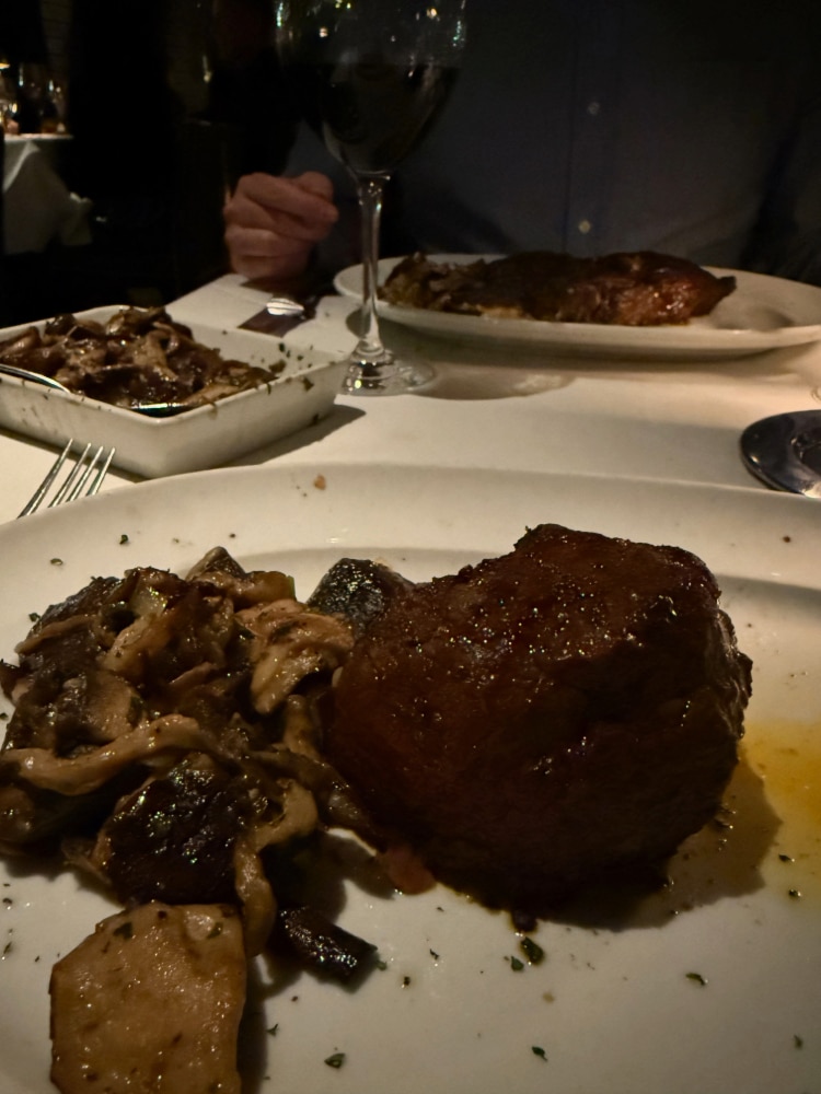 a filet mignon steak served with mushrooms on a white plate