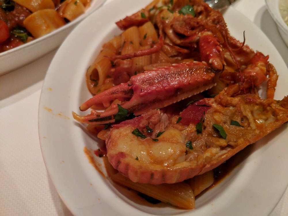 Seafood feast assembled on the plate - lobster with pasta and San Marzano sauce